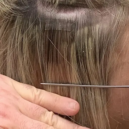 Pressing the section of hair onto the lower tape weft